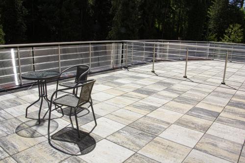 a patio with a table and chairs on a roof at Villa Pirken Hammer in Pirkenhammer