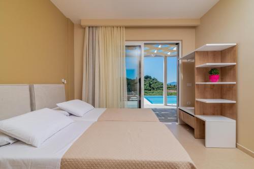 a bedroom with a bed and a view of a pool at Spartakos Luxury Villa 2 in Koukounariá