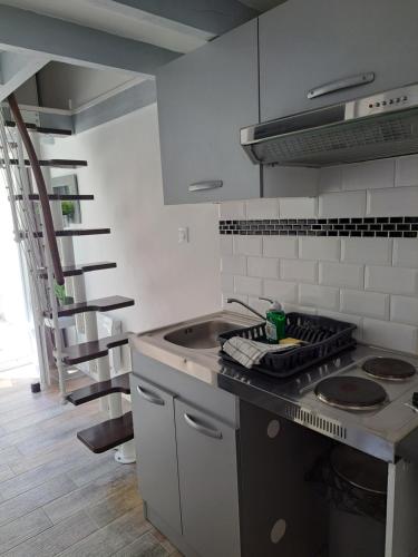a kitchen with a stove and a spiral staircase at Appart Madame à Chatelaillon plage 2 pers in Châtelaillon-Plage