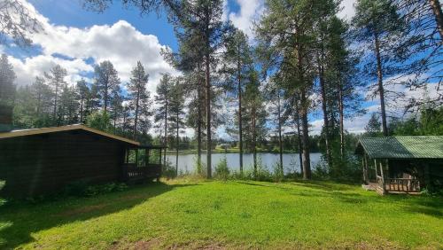 a large yard with a shed and a lake at Blockhaus am See in Arvidsjaur