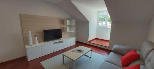 a living room with a couch and a tv at Apartamentos LEON XIII in Vilagarcia de Arousa