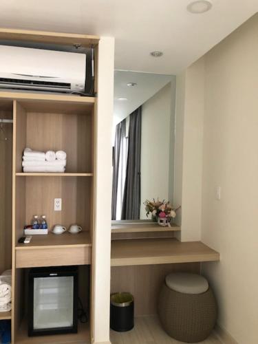 een kamer met een tv en een spiegel in een kamer bij Oceanami Villas & Beach Club 3 bedroom villa in Long Hai