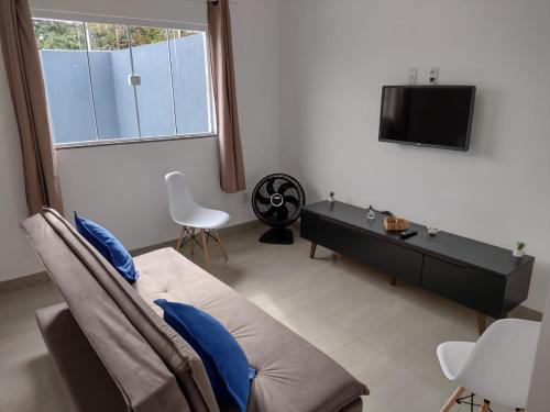 a living room with a couch and a tv at Casa Premium em Bonito - Linda e Confortável in Bonito