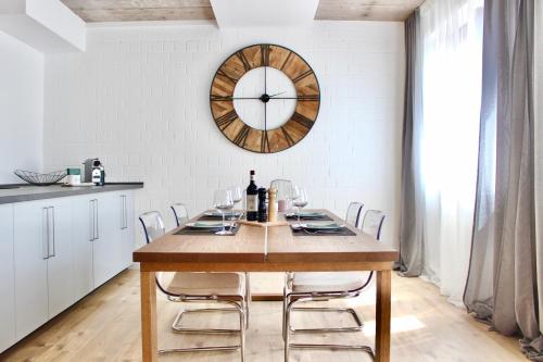 a dining room with a table and a clock on the wall at Vier Sind Hier Apartments in Rottweil