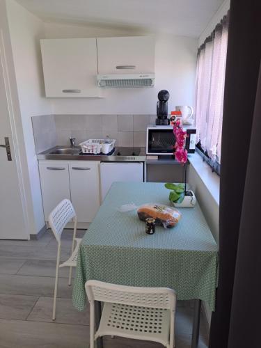 a kitchen with a table and a table and chairs at Appartement Aix (1 à 2 personnes) in Châtelaillon-Plage