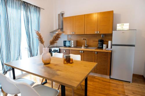 a kitchen with a wooden table and a refrigerator at Flat 126 in Alexandroupoli