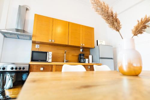 a kitchen with a table with chairs and a vase at Flat 126 in Alexandroupoli