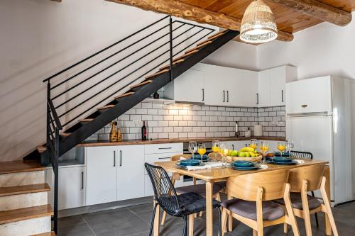 a kitchen with a wooden table and chairs at G&M House in Kefalás