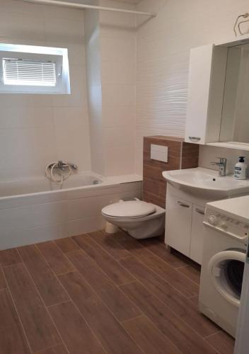 a bathroom with a toilet and a sink and a tub at Apartmani Popović Nin in Nin
