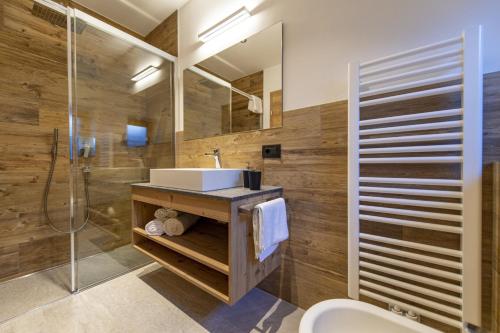 ein Bad mit einem Waschbecken und einer Dusche in der Unterkunft Luech da Perteut - Panorama and Wellness in St. Christina in Gröden