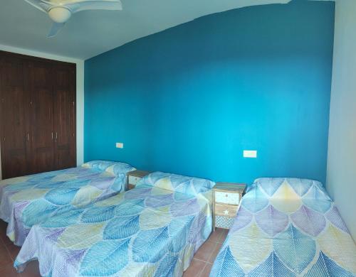 - une chambre avec 2 lits et un mur bleu dans l'établissement Valle del Este, à Vera