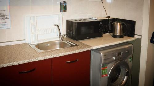 una cucina con lavandino, forno a microonde e lavatrice di Taksim Square-La Casa Home Concept a Istanbul
