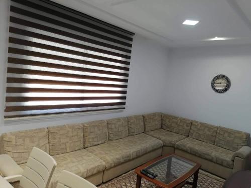a living room with a sectional couch and a table at Zayatine C7 in Sfax