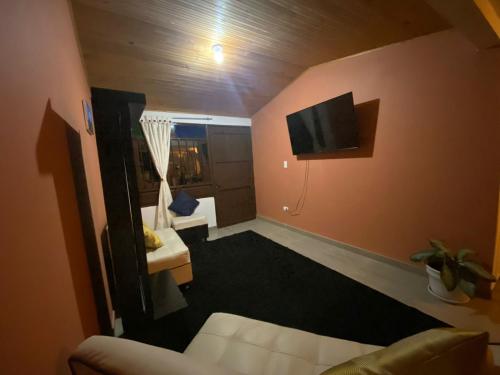 蒙圭的住宿－Hospedaje Aquitoy Sanoha，客厅配有沙发和墙上的电视
