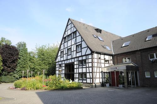 ein großes Schwarz-Weiß-Gebäude mit einem Innenhof in der Unterkunft Hotel der Lennhof in Dortmund