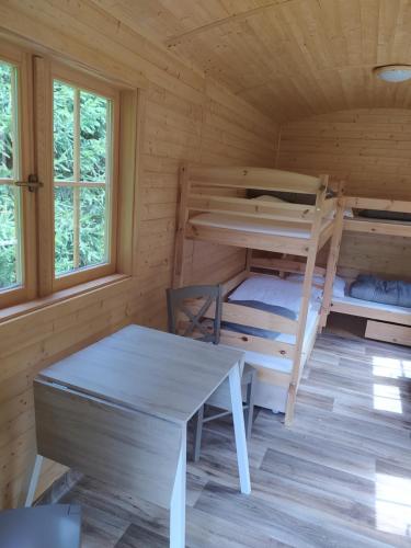 una habitación con literas y una mesa en una cabaña en Maringotka, en Tábor