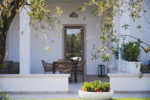 a patio with a table and chairs and plants at Dimorae Camà in Cisternino