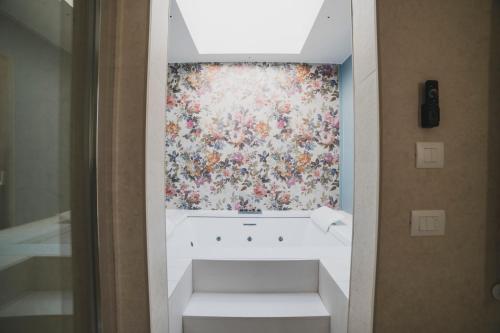 a bathroom with a painting of flowers on the wall at Dimorae Camà in Cisternino