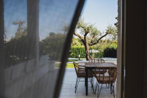 a table and chairs sitting on a balcony with a view of a yard at Dimorae Camà in Cisternino