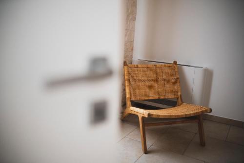 a wicker chair sitting in front of a refrigerator at Dimorae Camà in Cisternino