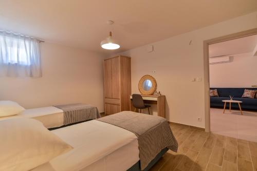 a hotel room with two beds and a mirror at Villa Rudini with heated pool in Okrug Gornji