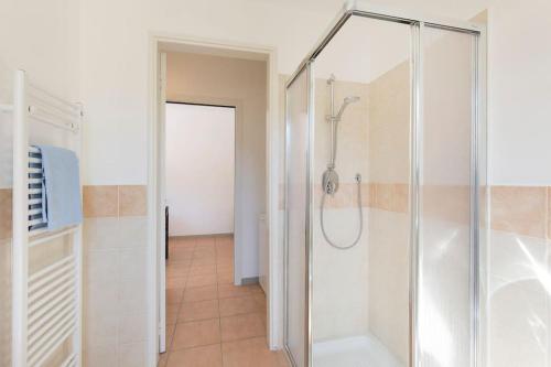 W łazience znajduje się prysznic ze szklanymi drzwiami. w obiekcie Appartamento Giuliano - Stresa w mieście Stresa