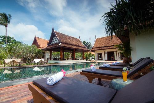 un resort con piscina e alcuni tavoli e sedie di Baan Thai Lanta Resort a Ko Lanta