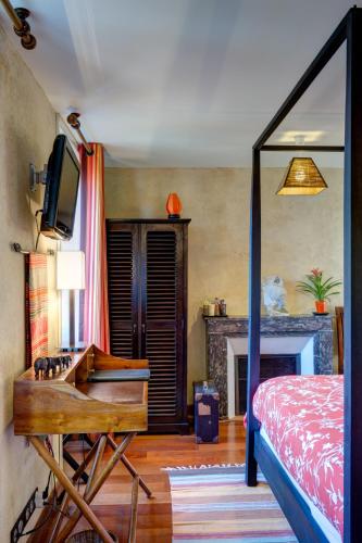 a bedroom with a bed and a tv and a fireplace at Maison de la Garenne & Spa in Vannes