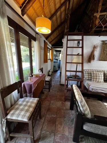 ein Wohnzimmer mit Stühlen, einem Tisch und einem Bett in der Unterkunft LO DE MARILITA in La Floresta