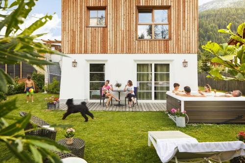 a group of people sitting on the deck of a house at Chalet Mi Amur in La Villa