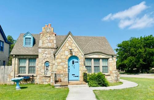 a stone house with a blue door at 1 mile to Fort Sill! The CaroleBelle Cottage sleeps 8 with hottub,grills,firepit in Lawton