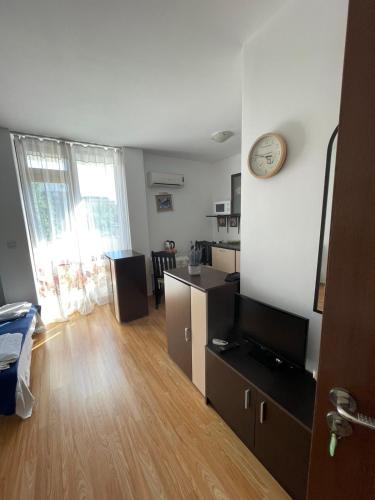 een woonkamer met een klok aan de muur bij Villa Flora SP apartments in Ravda