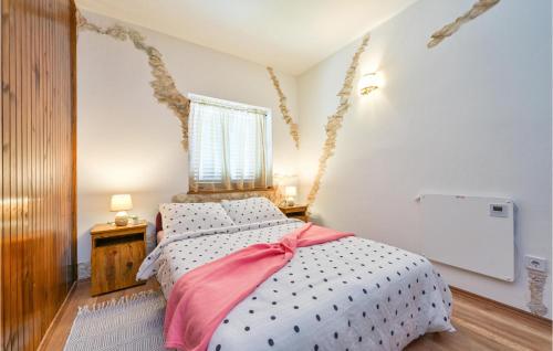 a bedroom with a bed with a pink bow on it at Lovely Home In Gornja Reka With Wifi in Lokošin Dol