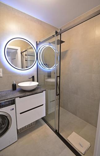 a bathroom with a glass shower and a sink at Sun Towers - Apartamenty Bryza - Apartamenty z parkingiem in Świnoujście