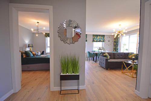 a living room with a couch and a table with a mirror at Sun Towers - Apartamenty Bryza - Apartamenty z parkingiem in Świnoujście