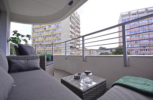 a balcony with a couch and a table at Sun Towers - Apartamenty Bryza - Apartamenty z parkingiem in Świnoujście