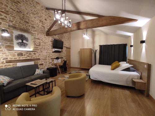 Habitación con cama y sala de estar con sofá. en Domaine de l'Orfraie en Saint-Juire-Champgillon