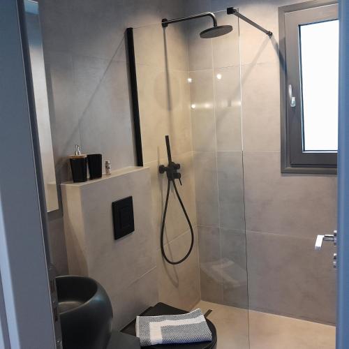 a bathroom with a shower with a glass door at Brand new flat near de bosset bridge, Argostoli in Argostoli