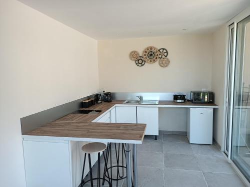 une cuisine avec des armoires blanches et un comptoir en bois dans l'établissement séjour bien-être balnéothérapie en vallée heureuse à Sorede, à Sorède