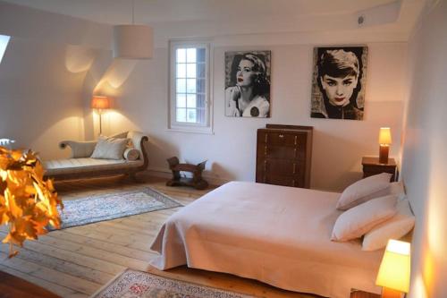 a bedroom with a large bed and a couch at Manoir Normand au cœur d’un Domaine Equestre in Saint-Samson
