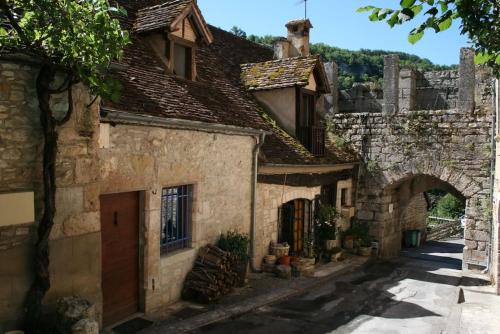 un callejón en un antiguo edificio de piedra con un arco en Gîte Rocamadour L'Oustal de Beline free wifi en Rocamadour