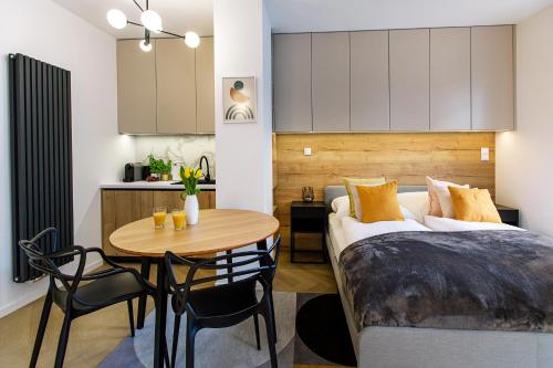 a bedroom with a bed and a table and a kitchen at Hillside7 Micro-Apartment 16 in Bielsko-Biała