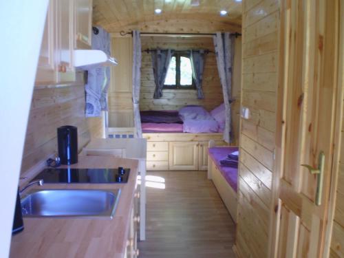 a kitchen and a sink in a tiny house at Les Roziers - Roulotte in Bagnac