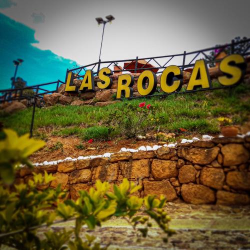 a sign that says lasrocas on a rock wall at Hotel Las Rocas Resort Villanueva in Villanueva