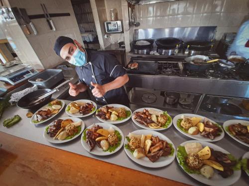 a chef in a kitchen with a bunch of plates of food at Hotel Las Rocas Resort Villanueva in Villanueva
