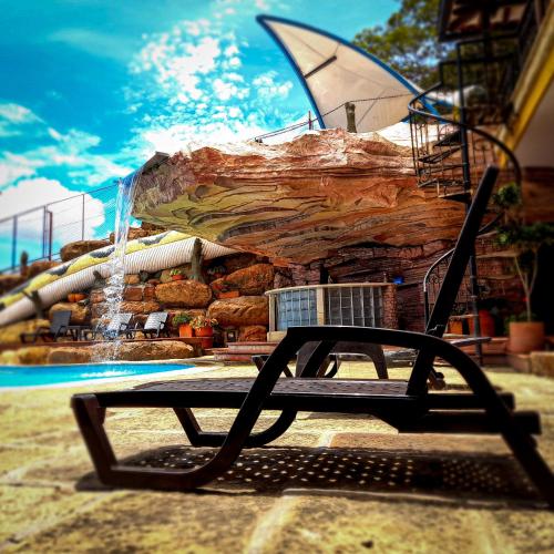 a bench in front of a pool with a fountain at Hotel Las Rocas Resort Villanueva in Villanueva