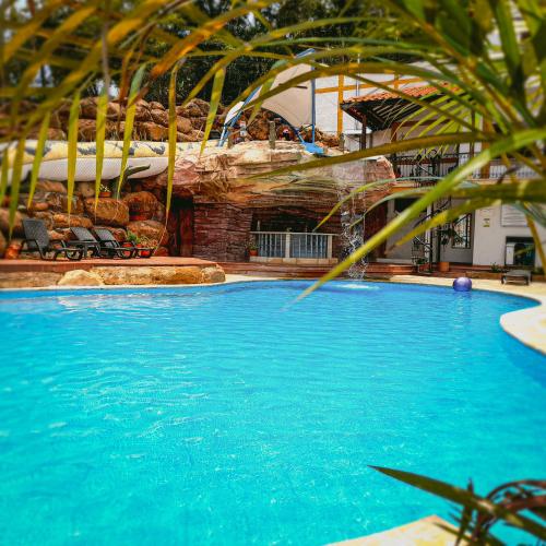 a swimming pool in a resort with blue water at Hotel Las Rocas Resort Villanueva in Villanueva