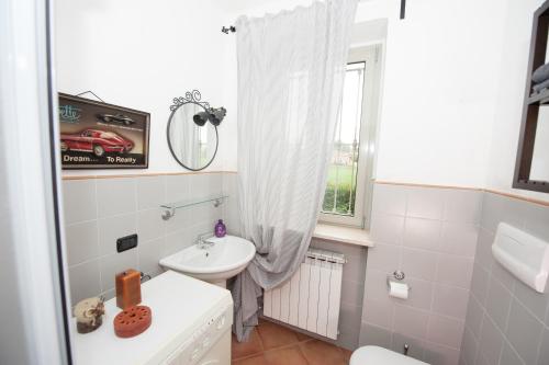 een badkamer met een wastafel, een toilet en een raam bij B&B La Pellizzera in Vigevano