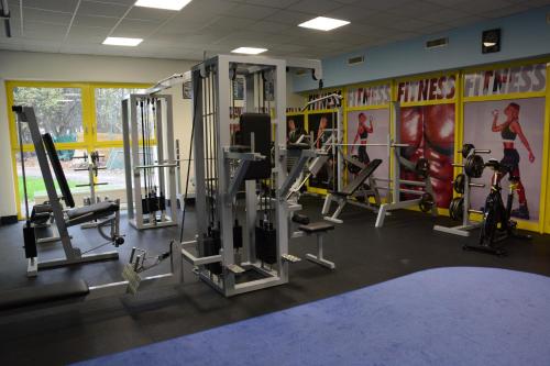 a gym with several tread machines in a room at Hotel Tennis Club in Prostějov