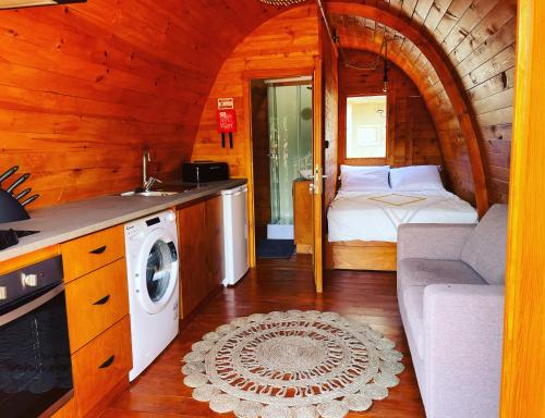 a kitchen and living room of a log cabin at The tiny black bird in Fajã da Ovelha